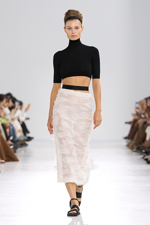 Défilé Max Mara Printemps Été 2026 : look avec col roulé raccourci noir et jupe blanche semi-transparente.