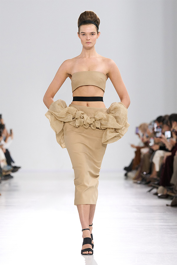Défilé Max Mara Printemps Été 2026 : look beige avec haut à bride et jupe à volants.