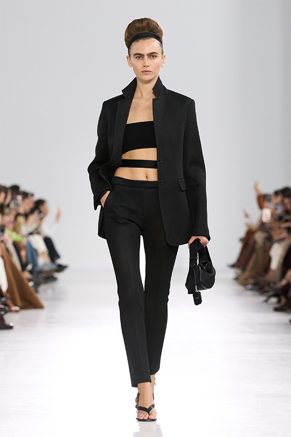 Défilé Max Mara Printemps Été 2026 : look avec blazer, haut à bride et pantalon noir assorti et petit sac noir.