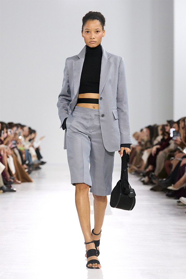 Défilé Max Mara Printemps Été 2026 : look avec blazer et bermuda assorti et sac noir.