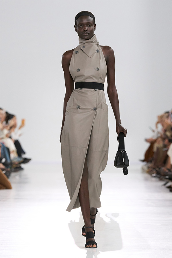 Défilé Max Mara Printemps Été 2026 : look gris avec trench-coat sans manche et petit sac noir.